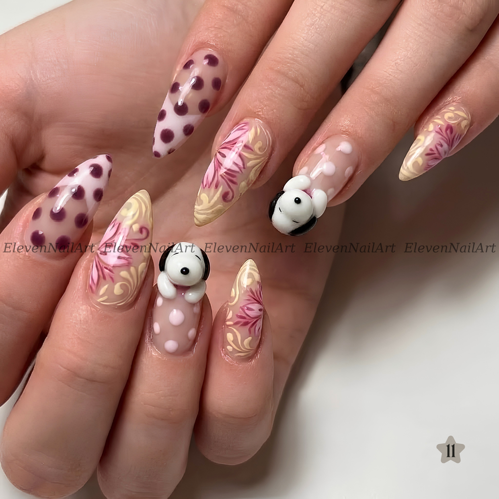 The nails feature a mix of solid white with dark red polka dots, beige and pink floral swirls, and a small 3D white bunny with black ears on one nail.