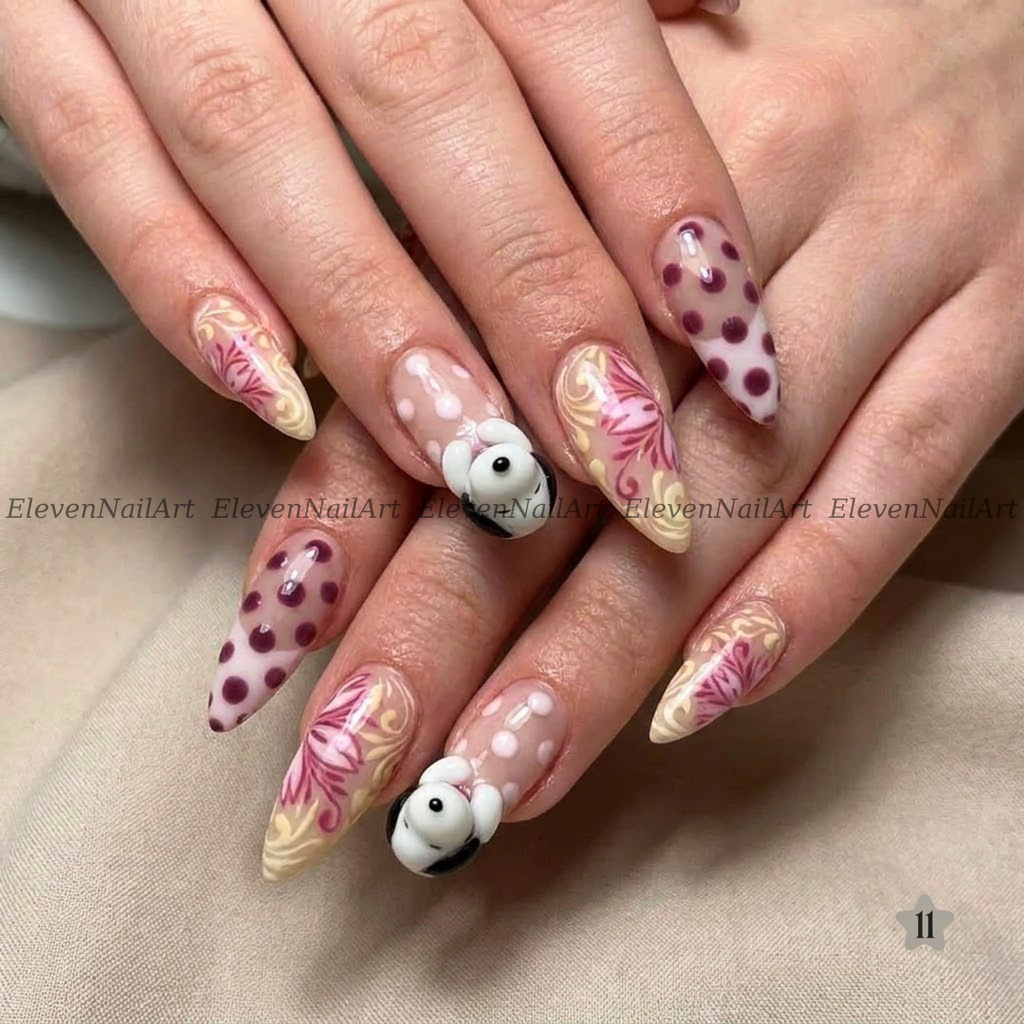 The nails feature a mix of solid white with dark red polka dots, beige and pink floral swirls, and a small 3D white bunny with black ears on one nail.