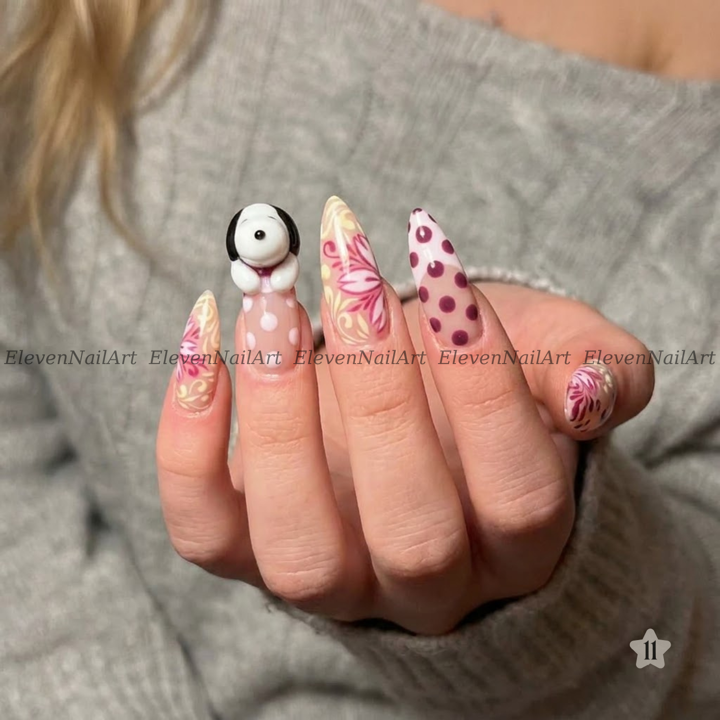 The nails feature a mix of solid white with dark red polka dots, beige and pink floral swirls, and a small 3D white bunny with black ears on one nail.