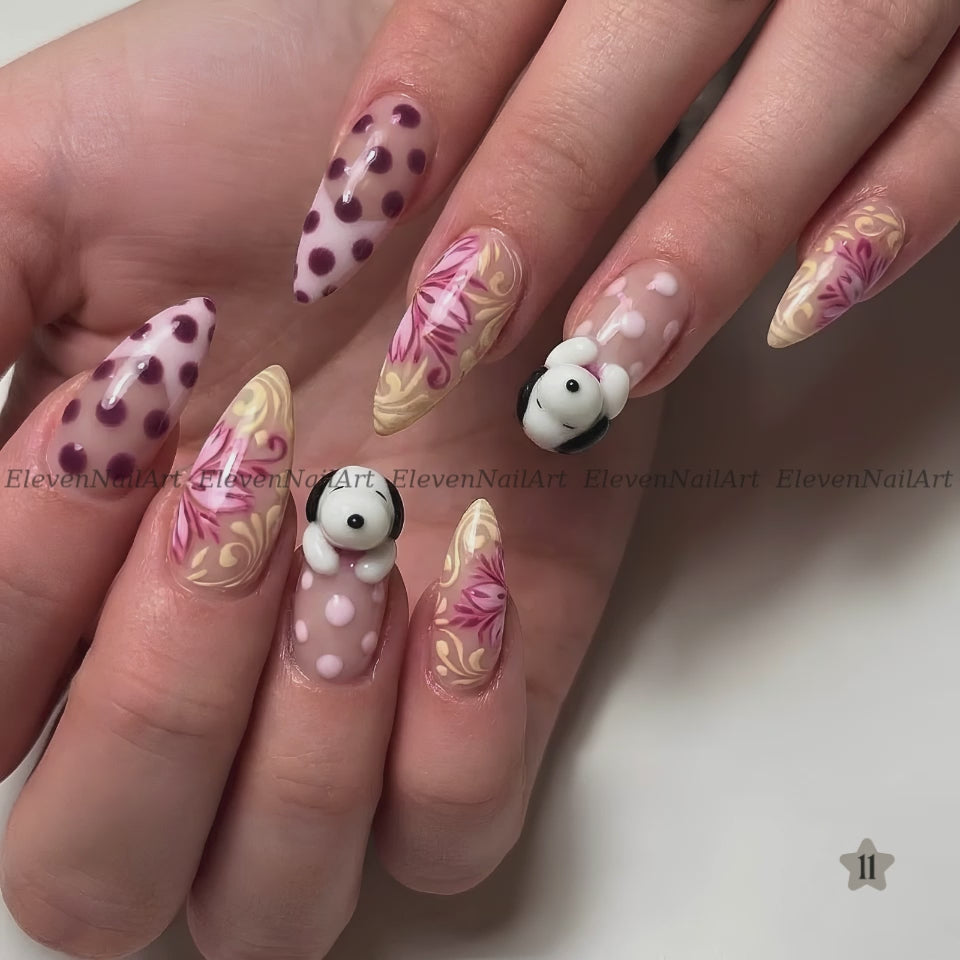 The nails feature a mix of solid white with dark red polka dots, beige and pink floral swirls, and a small 3D white bunny with black ears on one nail.